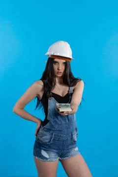 A young construction manager distributes banknotes to everyone who starts wor Fotos Stock