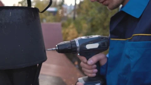 A young construction worker in blue overalls and a white helmet repairing the ch Stock Footage 80243359