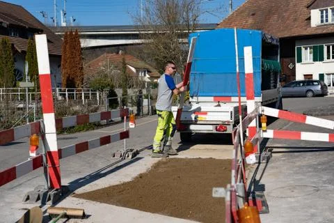 Young construction worker is clearing away barriers of a constructon site. Stock Photos