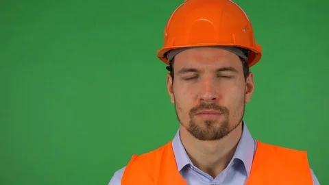 A young construction worker looks seriously at the camera - closeup - green Stock-Footage 115083319