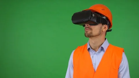 A young construction worker uses VR glasses - green screen studio - he looks Stock-Footage 115082808