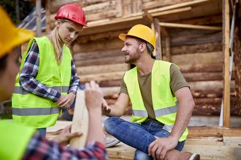 Young construction workers man and woman talking.Teamwork.Building. woodwor.. Stock Photos