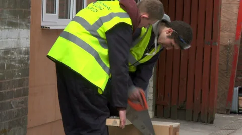 Young construction workers sawing wood Stock Footage 30451458