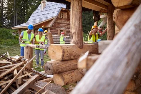 Young construction workers team building a mountain house project together;.. Stock Photos