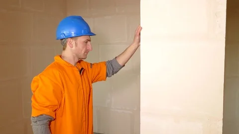 Young constructor checking the wall with level tool Stock Footage 71940470