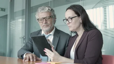 Young content assistant showing project data to CEO via tablet Stock Footage 138786511