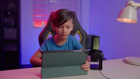 Young Content Creator Smirks While Watching Tablet Screen in Home Studio Stock Footage 345963309
