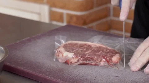 Young cook takes meat from package in kitchen of cafe. Stock Footage 84581454