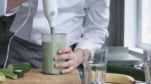 Young cook in uniform preparing vegetable smoothie 스톡 동영상 74507788