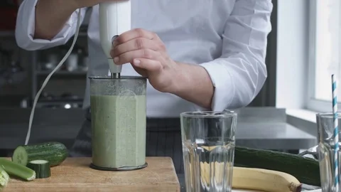 Young cook in uniform preparing vegetable smoothie Stock Footage 74507992