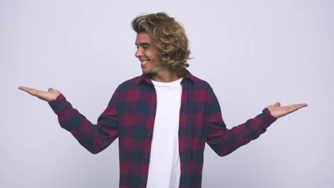Young cool australian man makes scale with arms, feels happy and confident Stock Footage 139577892