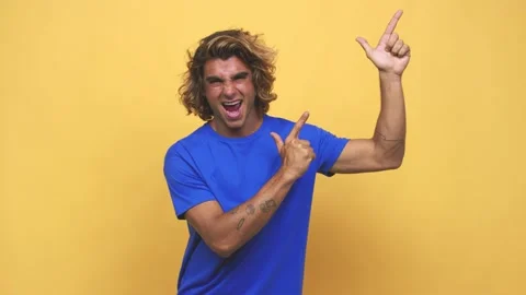 Young cool australian man pointing with forefingers to a copy space, expressing Stock Footage 139577066