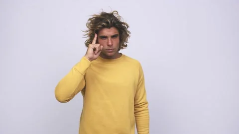 Young cool australian man pointing temple with finger, thinking, focused on a Stock Footage 139577784