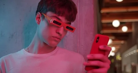 Young Cool Guy in Stylish Modern Party Glasses Standing aside Leaned to Wall and Stock Footage 118445796