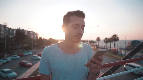 Young cool man is using, tapping mobile phone Stock Footage 112893720