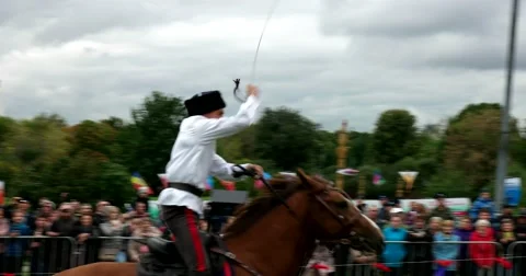 Young Cossack perform elements of trick riding on horses Stock Footage 66186160