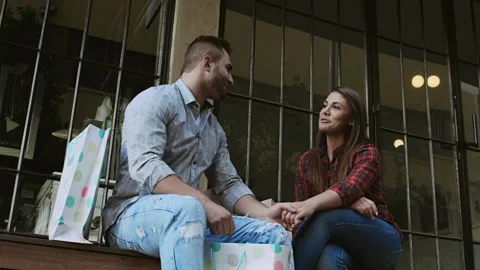 Young couple admiring and comparing shopping gifts from the days shopping. Stock-Footage 199632100
