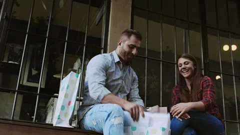 Young couple admiring and comparing shopping gifts from the days shopping. Stock Footage 199632128