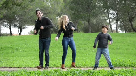 Young couple and child dancing in a park Stock Footage 45123812