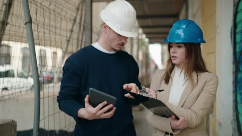 Young couple architect partners using touchpad and clipboard working at stree Stock Footage 171405877