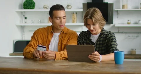 Young couple are doing online shopping in kitchen Stock Footage 113290729