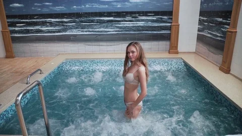 Young couple are having fun in the swimming pool Jacuzzi, bubbles, relaxation Stock Footage 75503579