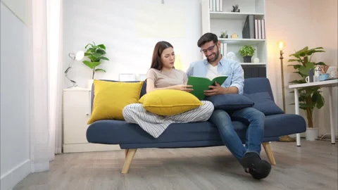 Young couple are smiling while relax and working online via laptop Video stock 309014180