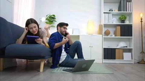 Young couple are smiling while relax and working online via laptop Stock Footage 309015730