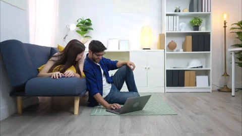 Young couple are smiling while relax and working online via laptop Stock Footage 309016136