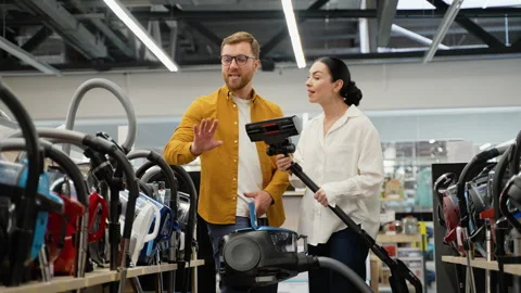Young couple arguing over choosing a vacuum cleaner Stock Footage 279638079