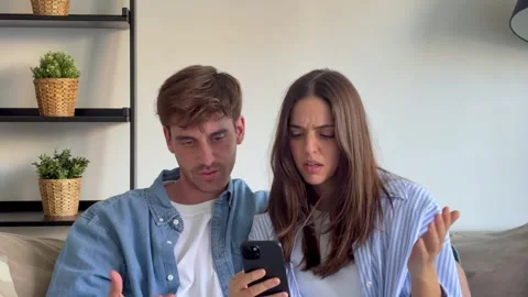 Young couple arguing while using smartphone Stock Footage 335588217