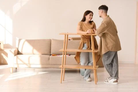 Young couple assembling shelf unit at home Stock Photos
