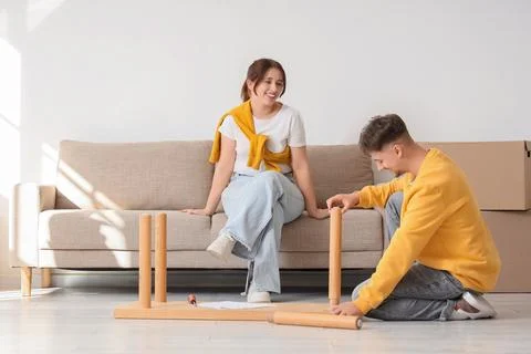 Young couple assembling wooden bench at home Stock Photos
