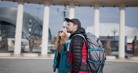Young Couple Backpackers Explore a New City on a Sunny Day, Visiting Famous Stock Footage 344829553