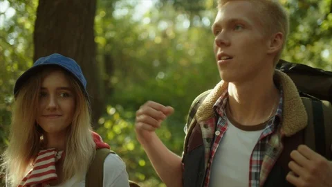 Young couple with backpacks having a walk in the forest Stock Footage 96181926