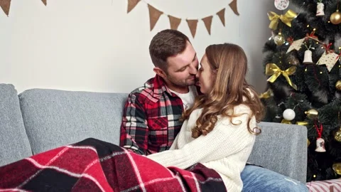 A young couple basks under a warm blanket and enjoys each other Vídeos de archivo 144613808