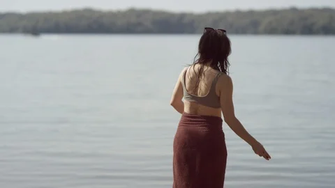 A young couple in bathing suits skip rocks at a large lake in slow motion Stock-Footage 116753602