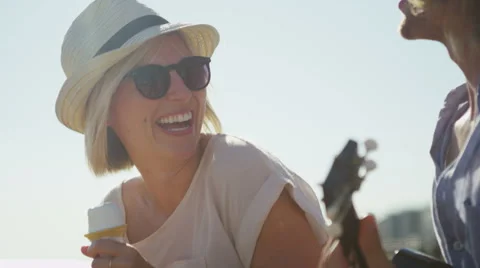 Young couple on the beach having fun with music and ice cream in slow motion Stock Footage 52144096