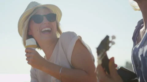 Young couple on the beach having fun with music and ice cream Stock Footage 52155690