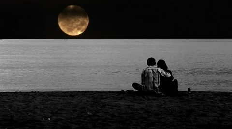 Young couple on beach set against timelapse full moon Stock-Footage 1036171