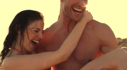 Young couple on beach in sunset, man twirling woman round. Stock Footage 43661939