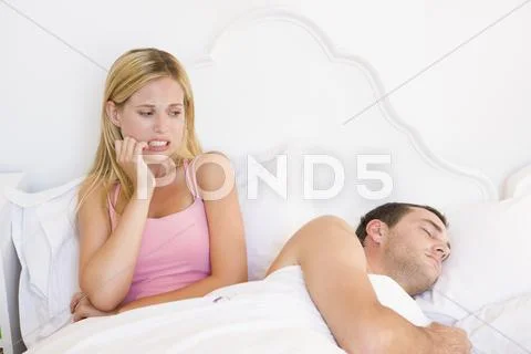 Young couple in bed having trouble sleeping Stock Photos