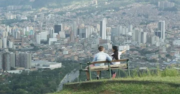 Young couple on bench overlooking and pointing at city skyline Stock Footage 86149367