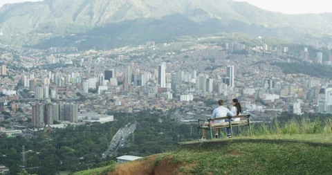 Young couple on bench overlooking and pointing at city skyline Stock Footage 86149463