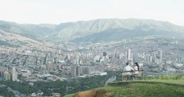 Young couple on bench overlooking city skyline Stock Footage 86149382