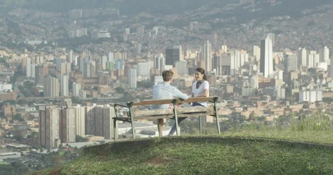 Young couple on bench overlooking city skyline Stock Footage 86150444