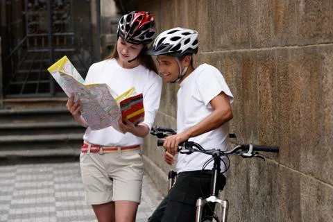 Young couple with bicycles looking at map Stock Photos