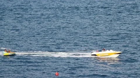 Young couple bounce up over wake on a tube. Tubers on their donut being towed Stock Footage 273402005