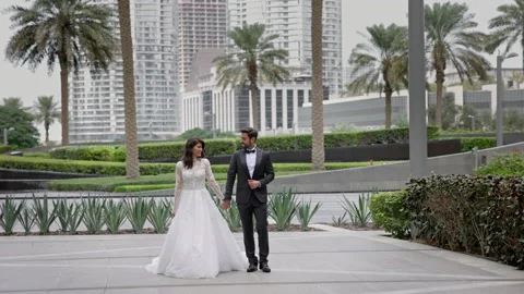 Young Couple Of Brides Walking Down The Street In Dubai Holding Hands. Wonderful Stock Footage 153732576
