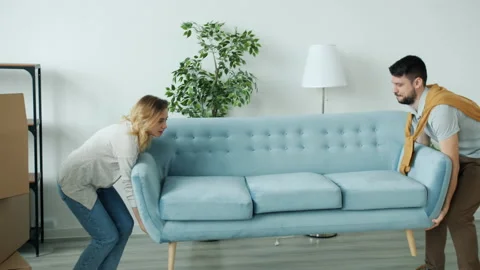 Young couple bringing new sofa to apartment then sitting relaxing enjoying rest 스톡 동영상 144576882